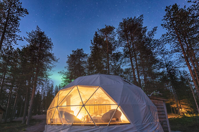 The incredible Aurora Dome in Finland, lit up at night beneath unspoilt starry skies and Lappish forest