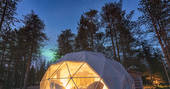 The incredible Aurora Dome in Finland, lit up at night beneath unspoilt starry skies and Lappish forest