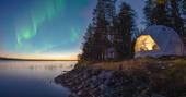 The beautiful Aurora Dome in Finland, overlooking the lake with the Northern Lights above