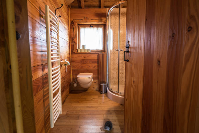 Bathroom with shower and flushing toilet at Gauthie Treehouse Cabin, Dordogne, France
