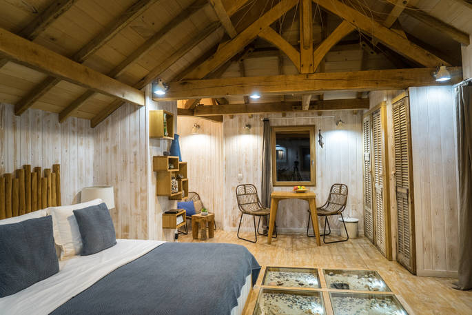 Kingsize bed and seating area at Chateau Biron, Châteaux dans les Arbres, Dordogne, France