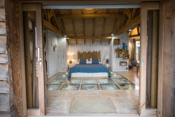 Looking inside to the bedroom from the terrace at Chateau Biron, Châteaux dans les Arbres, Dordogne, France