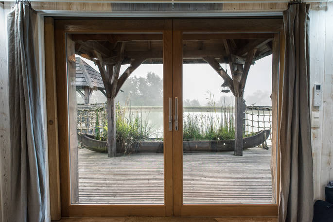 View onto the lake from the bedroom at Chateau Biron, Châteaux dans les Arbres, Dordogne, France