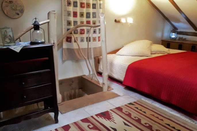 Wonder upstairs where you will find the warm bedroom space at Woodman's Cabin in Dordogne, France