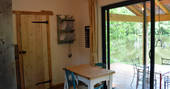 Wooden dining table inside of the patio doors in GoGreen cabin at GoGreen holidays 