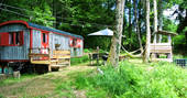 A view of the GoGreen Roulette hut with outdoor dining space and hammock in Dordogne, France