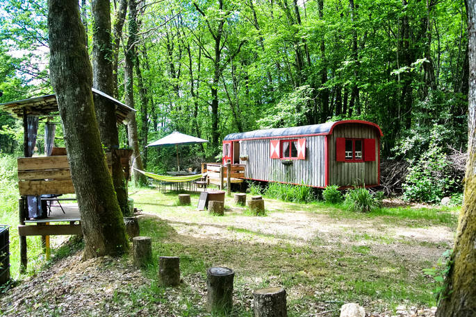 A view of the GoGreen Roulette with two covered dining areas and a hammock in Dordogne, France