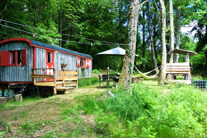 A view of the GoGreen Roulette hut with outdoor dining space and hammock in Dordogne, France