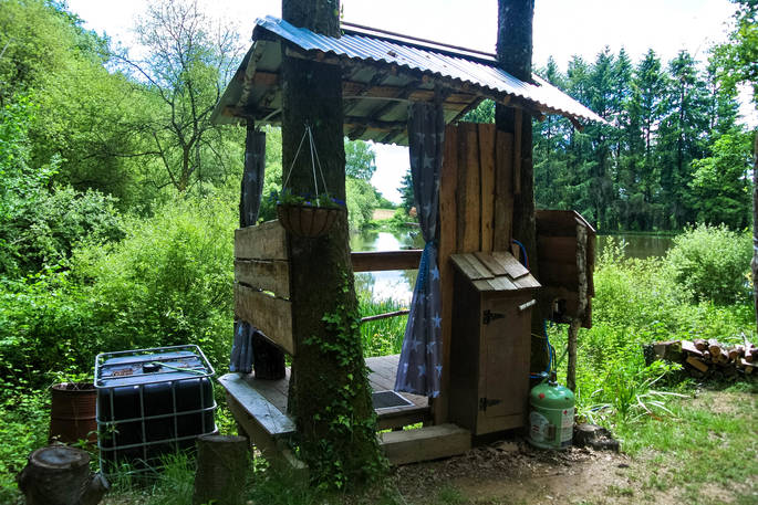 The outdoor shower hut, overlooking the lake at GoGreen Roulette in Dordogne, France