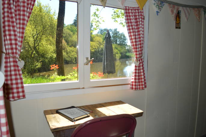 Seating area inside GoGreen Roulotte looking out on the gorgeous lake outside 