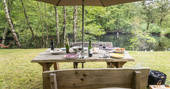 A grand table for dining by the lake at Poacher's Cabin in Dordogne, France