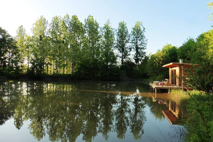Sit on the deck over the lake at Caru Cabin in Dordogne, France