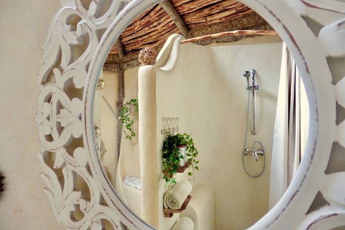 The bathroom with large white mirror at Elvensong in Dordogne, France