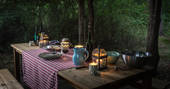 Woodland dining by candlelight at Elvensong cabin in Dordogne, France