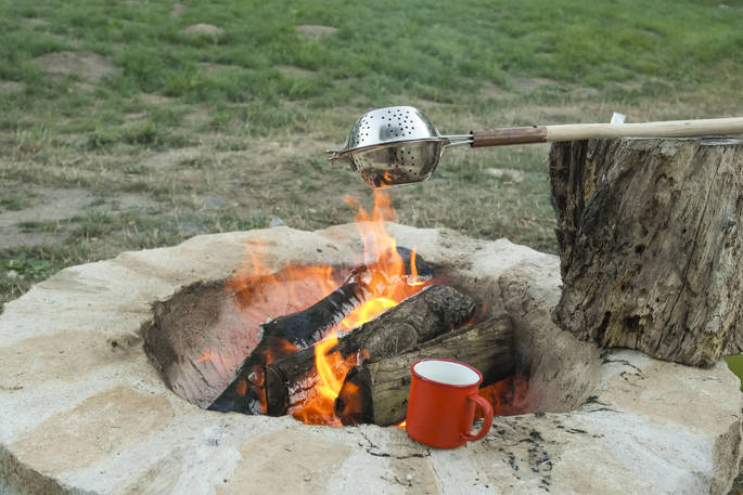 Cooking on the lit outdoor firepit at Bot-Conan lodge in France