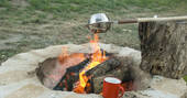 Cooking on the lit outdoor firepit at Bot-Conan lodge in France