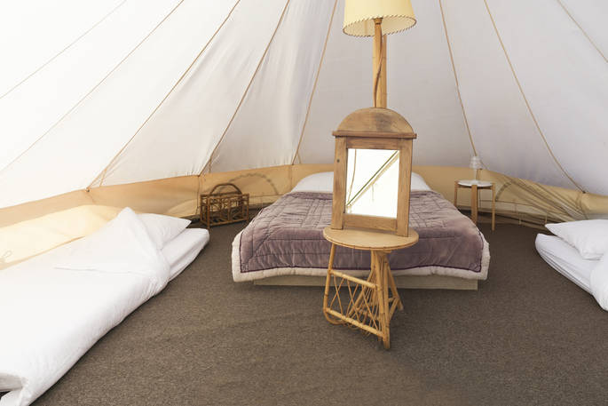 Interior of Atoll bell tent with one double bed and two single beds