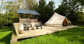 Sit outside on the wooden decking outside of Atoll bell tent at Bot-Conan Lodge in France