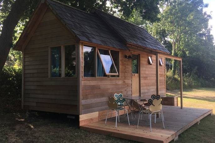 Exterior of La Cabane de Bot-Conan with wooden decking and seating area at Bot-Conan Lodge in France
