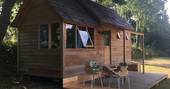 Exterior of La Cabane de Bot-Conan with wooden decking and seating area at Bot-Conan Lodge in France