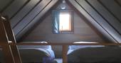 Two single beds on the mezzanine level inside the cabin at Bot-Conan in France