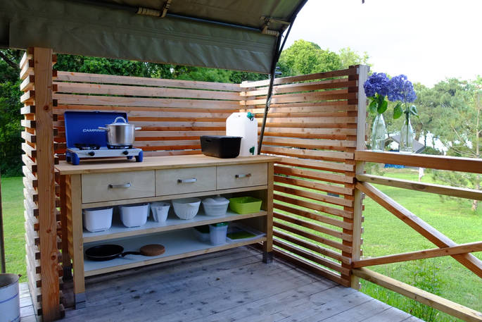 Kitchen facilities on the wooden decking outside of the safari tents in France