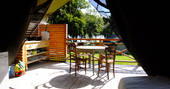 Outdoor dining table and kitchen area in the sun outside of Penfret lodge tent