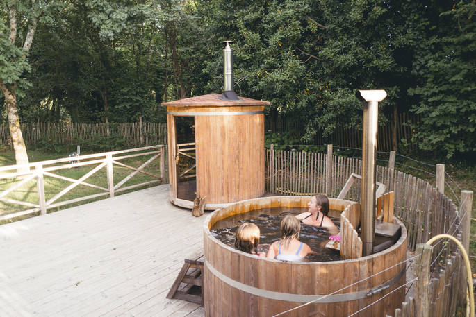 Relax in the outdoor hot tub with friends at Bot-Conan Lodge in France 