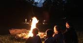 Sitting around the campfire at Cabane de Salagnac Cèdre Gris, Corrèze, France