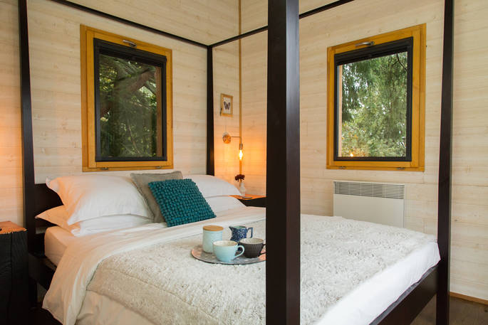 King-size bed in Sommet de Memanat treehouse at Château de Memanat one hour from Limoges Airport