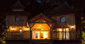 Sommet de Memanat treehouse glowing in the night sky at Château de Memanat in France