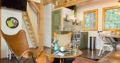 Sommet de Memanat treehouse interior open plan living area with ladder leading up to twin single beds in turret 