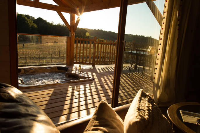 View of the sunken hot tub from the lounge area inside of Sommet de Memanat in France
