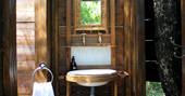 Wooden ensuite with sink and towel for guests of Meru at Le Camp 