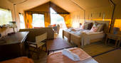 Interior of Mount Kenya with king size bed and seating areas in the Penthouse safari tent 