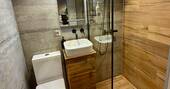 Bathroom with a hot shower, sink and flushing toilet