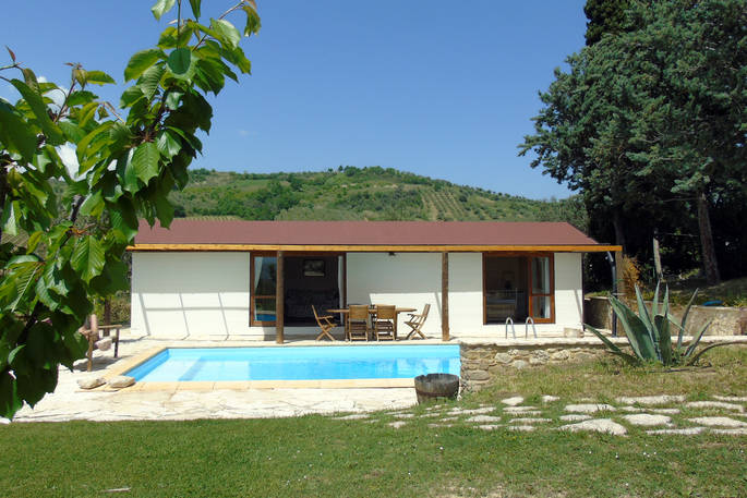 The Pool House whitewash cabin exterior with private pool at Glamping Abruzzo
