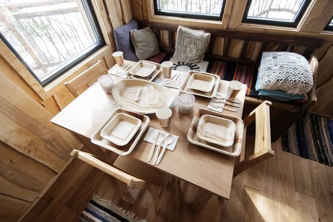 Close up of the dining area inside Treetop Fiddan with wooden utensils and equipment 