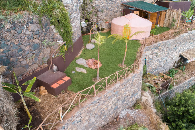 Mango Yurt aerial view with outdoor seating area and fire pit at Canto das Fontes in Portugal