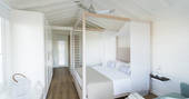 The light and airy bedroom of Cidreira tree bungalow with king-size four poster bed 