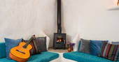 Seating area with guitar and wood burner at Casa Isadora Cave House, Almeria, Spain